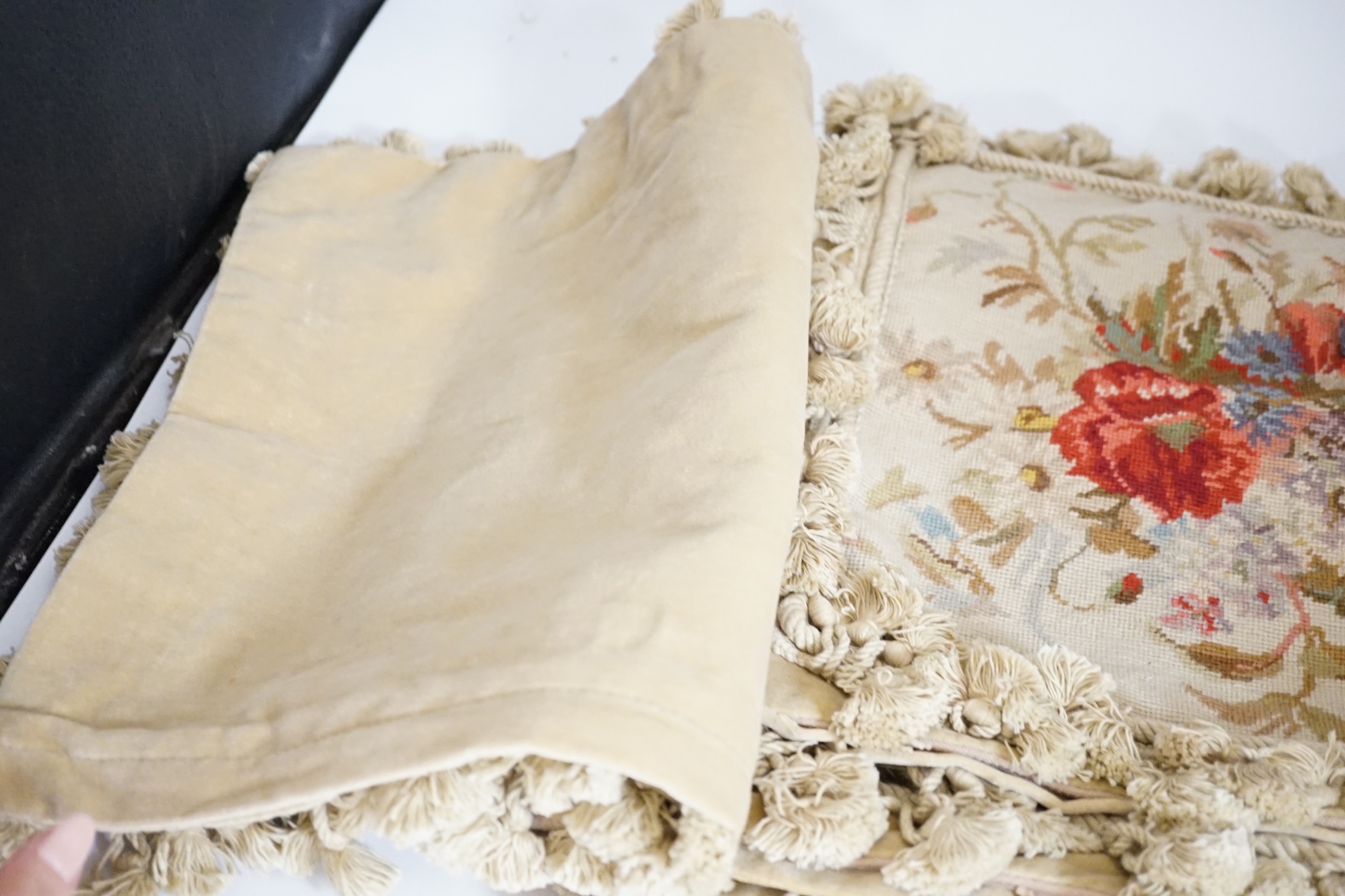 Five square wool worked cushion covers designed with wild flowers, bordered with tasselled braiding